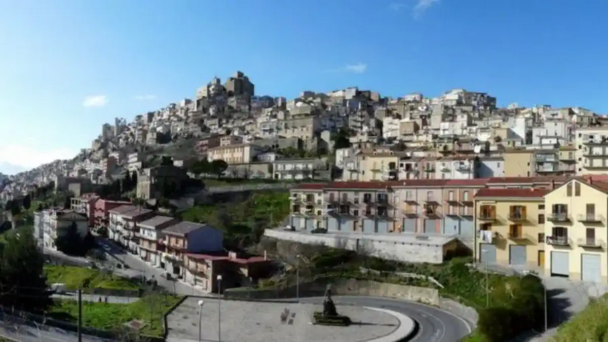 Дом за 1 евро в Сицилии реальные условия и лучшие коммуны Светлое редакционное 16:9 изображение: узкая сицилийская улочка, табличка «Asta / 1€», планы ремонта на столе