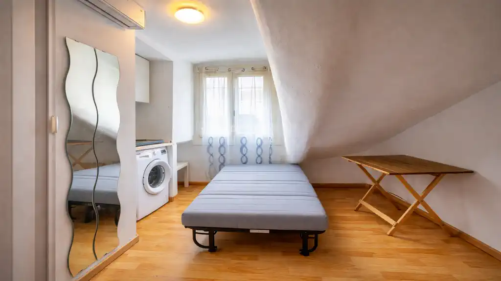 Компактная мансардная студия в Турине с раскладной кроватью, мини-кухней и окном